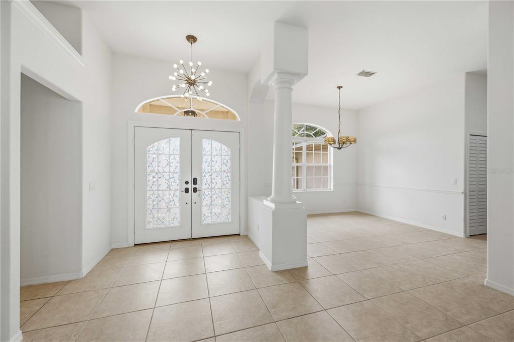 An entryway with tile floors, a double front door, and a columned dining area — 3691 SESAME STREET, NORTH PORT, FL