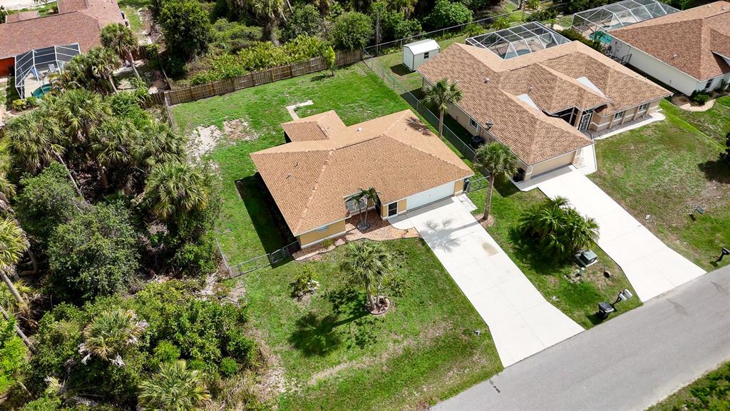 An aerial view shows a single-story house with a brown roof and a concrete driveway — 3781 WAYWARD AVENUE, NORTH PORT, FL