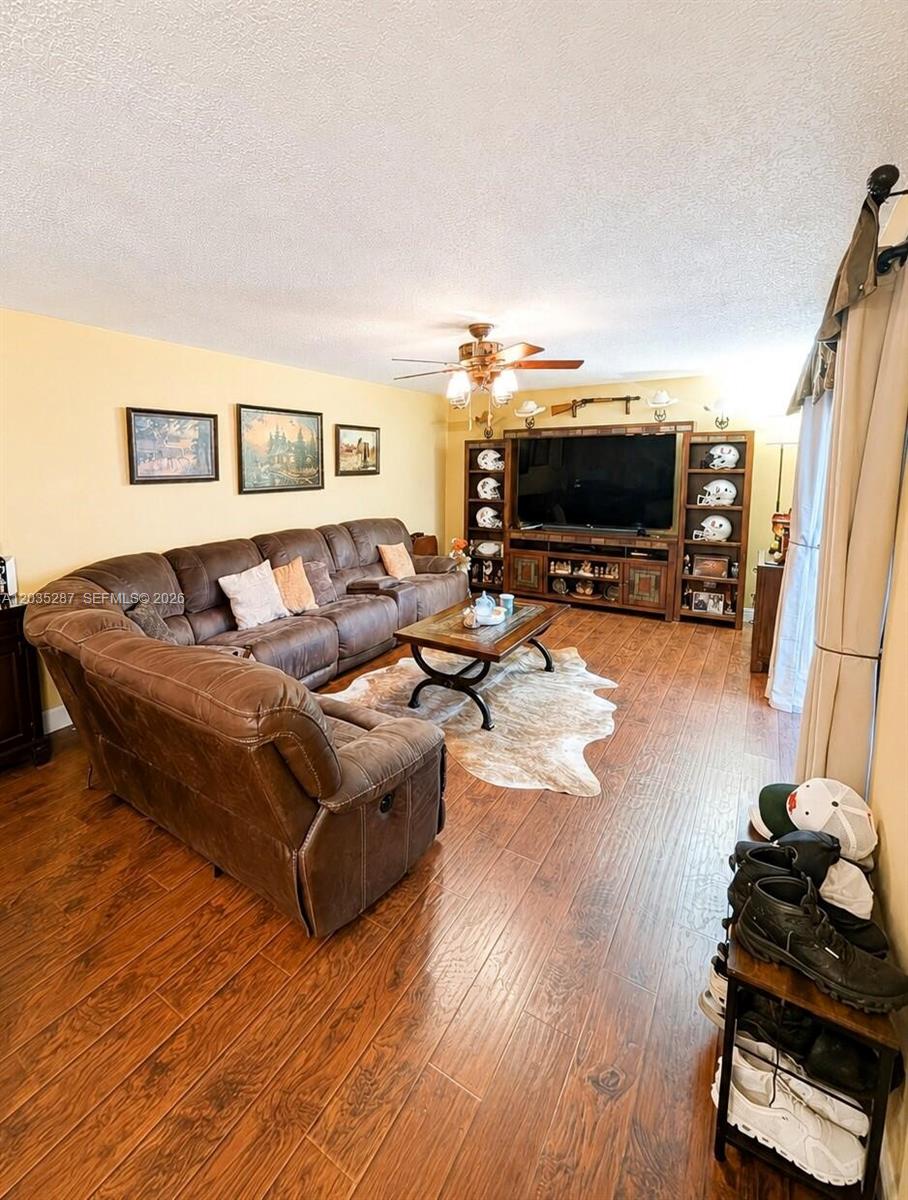 A living room features a large brown sectional sofa, wood flooring, and a media console — 2589 Garden # 2589, Hollywood FL 33026, HOLLYWOOD, FL
