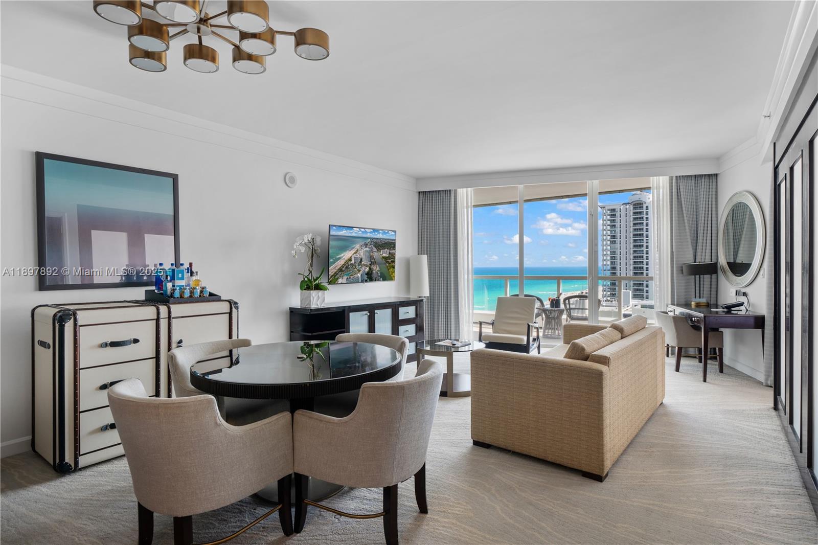 A living and dining area features a round table, sofa, and balcony with ocean views — 4391 Collins Ave # 1619, Miami Beach FL 33140, MIAMI BEACH, FL