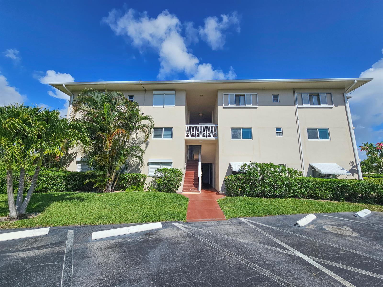 A three-story apartment building with a central staircase and a parking lot in front — 2562 Garden Drive N # 202, FL 33461, FL