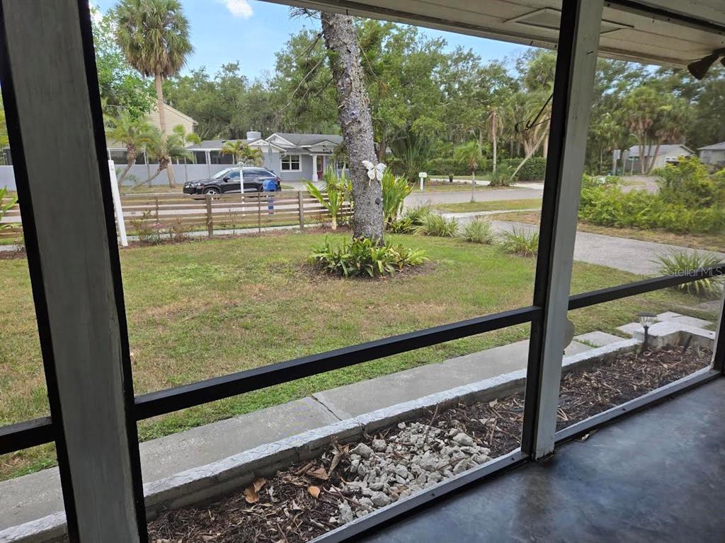 A view from a screened-in porch looking out onto a front yard and street — 859 PATTERSON DRIVE, SARASOTA, FL