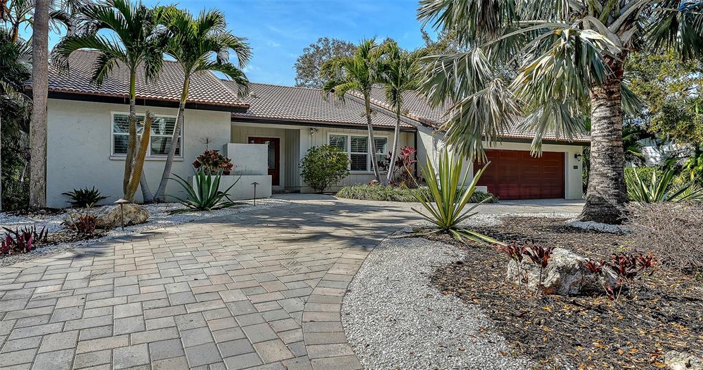 A single-story house with a paved driveway, palm trees, and a two-car garage — 5231 SIESTA COVE DRIVE, SARASOTA, FL