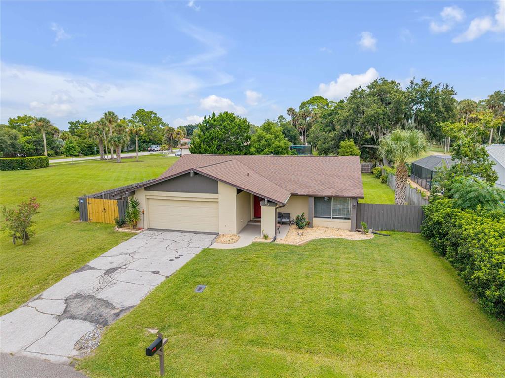 An aerial view of a single-story house with a cracked concrete driveway and green lawn — 3 CASPER DRIVE, PALM COAST, FL