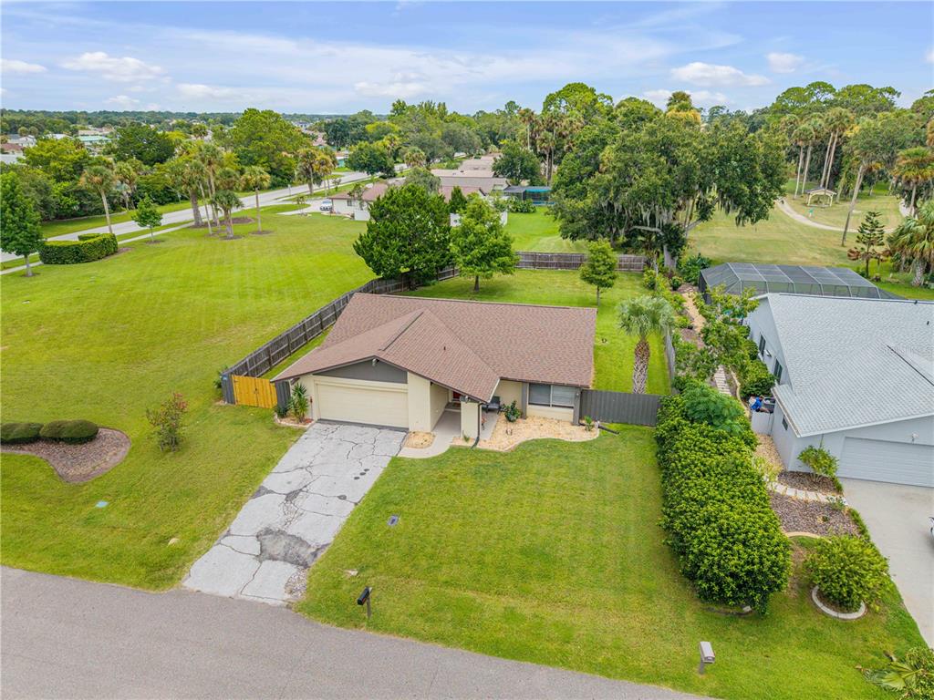 An aerial view shows a single-story house with a brown roof and a cracked driveway — 3 CASPER DRIVE, PALM COAST, FL