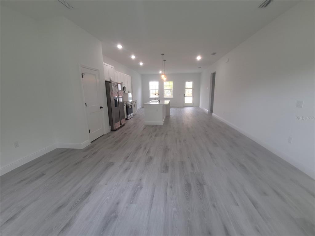 An open-concept kitchen and living area features white cabinetry, a central island, and light flooring — 16629 SW 21ST CIRCLE, OCALA, FL