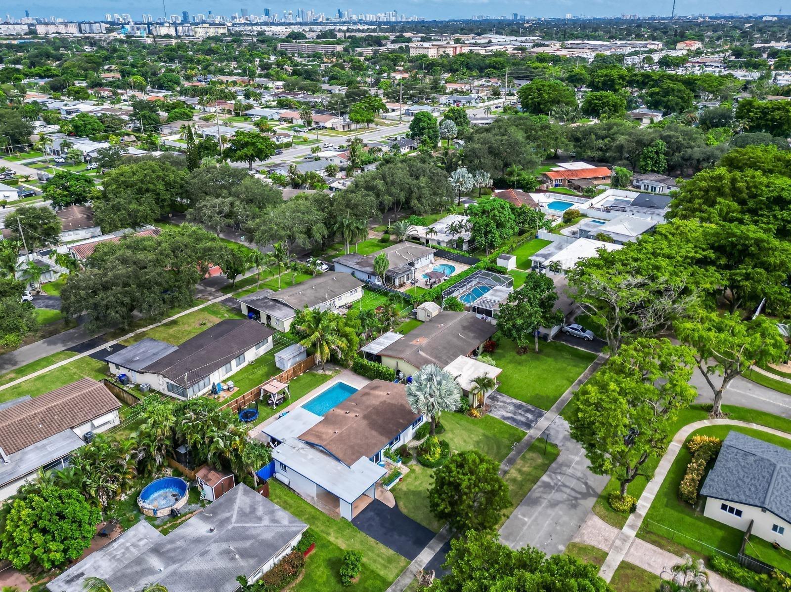 An aerial view of a suburban neighborhood featuring single-family homes with swimming pools and trees — 315 S 57th Avenue, Hollywood FL 33023, HOLLYWOOD, FL