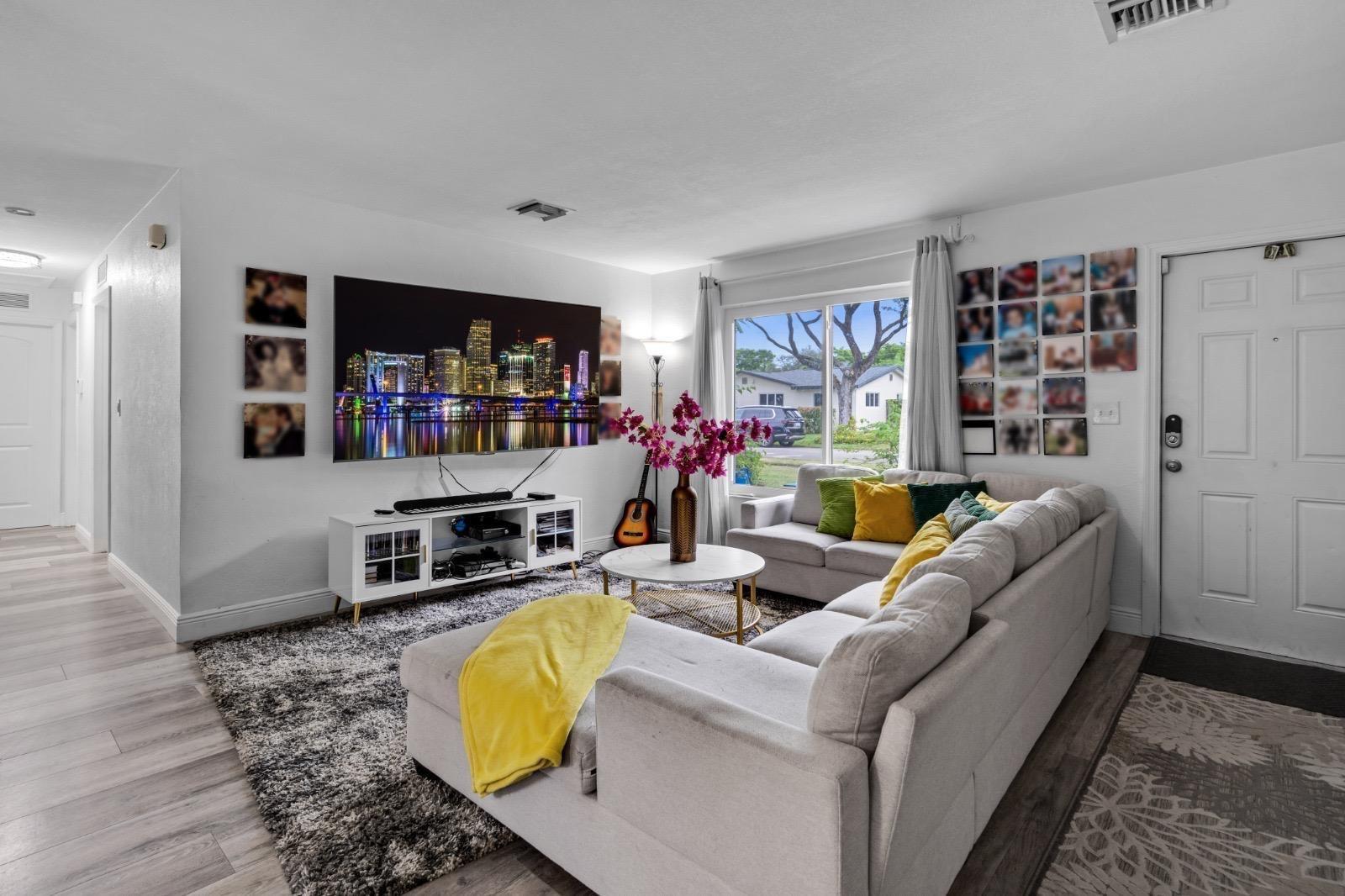 A living room features a large sectional sofa, a wall-mounted television, and a white console — 315 S 57th Avenue, Hollywood FL 33023, HOLLYWOOD, FL