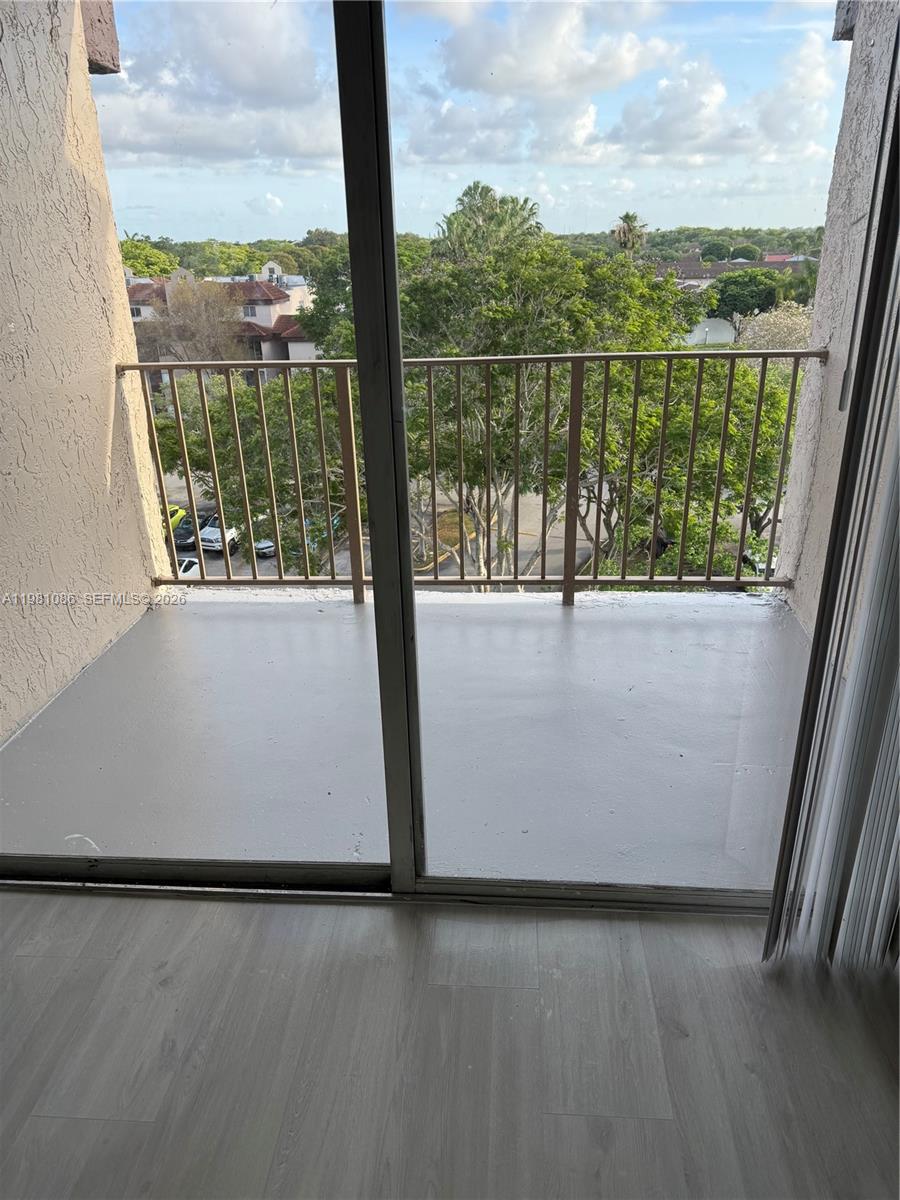 A view from inside a room looking out through sliding glass doors onto a balcony — 15231 SW 80th St # 615, Miami FL 33193, MIAMI, FL