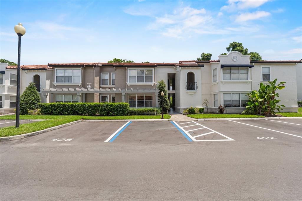 A two-story apartment building with a parking lot in the foreground — 5116 CONROY ROAD UNIT 15, ORLANDO, FL