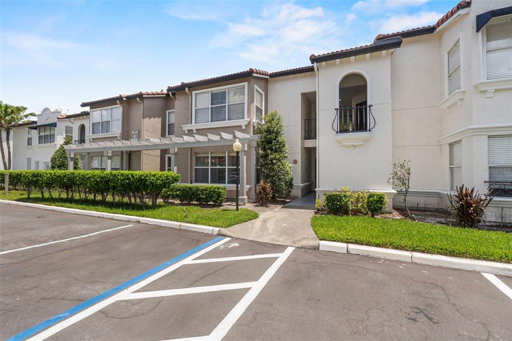 An exterior view of a two-story apartment building with a pergola and parking lot — 5116 CONROY ROAD UNIT 15, ORLANDO, FL