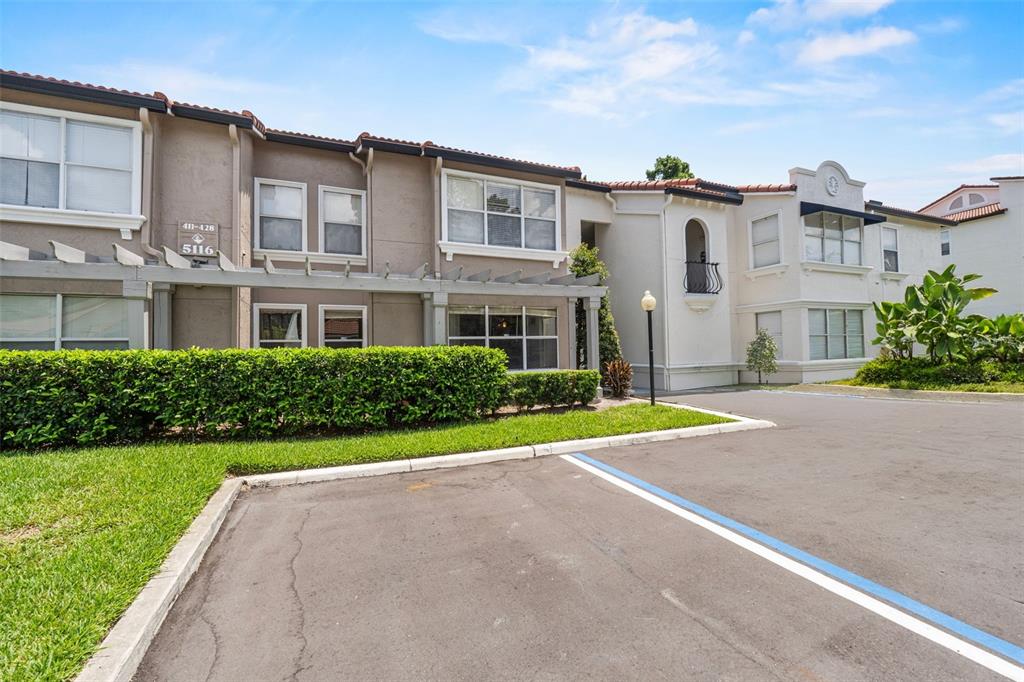 A two-story apartment building with a pergola, manicured hedges, and a paved parking area — 5116 CONROY ROAD UNIT 15, ORLANDO, FL