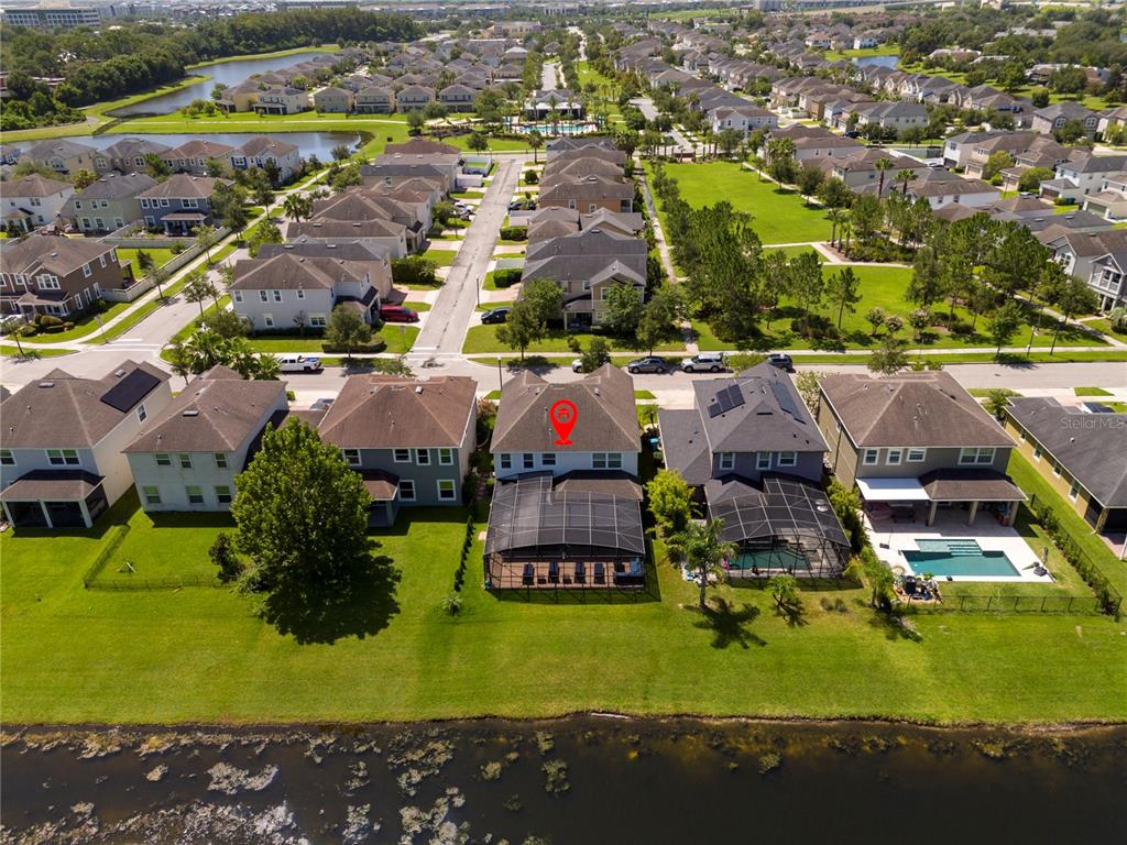 An aerial view shows a suburban neighborhood with houses, a pond, and a marked residence — 5185 DOVE TREE STREET, ORLANDO, FL