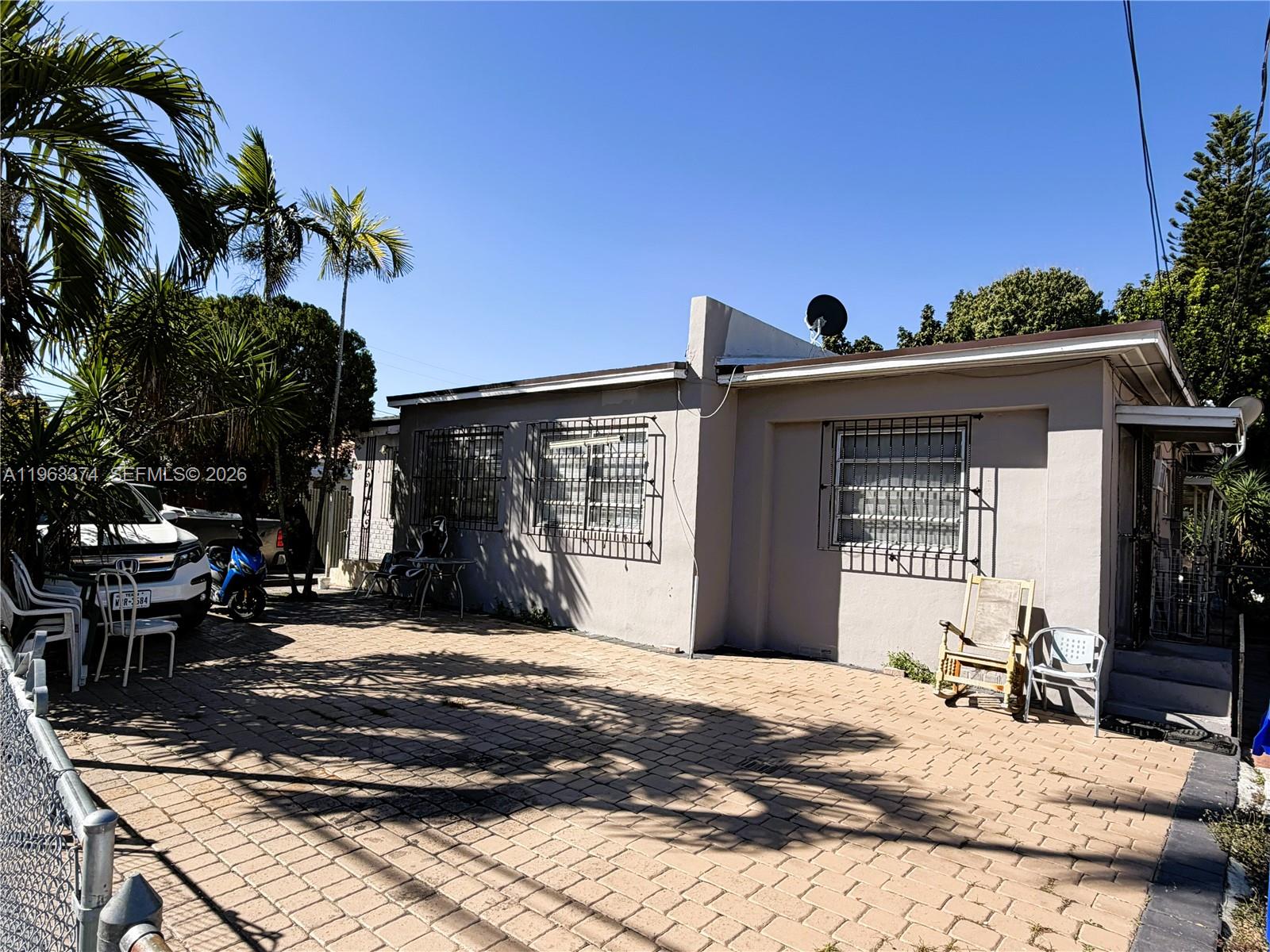 A single-story house with a paved driveway, security bars on windows, and palm trees — 430 NW 53rd Ave, Miami FL 33126, MIAMI, FL