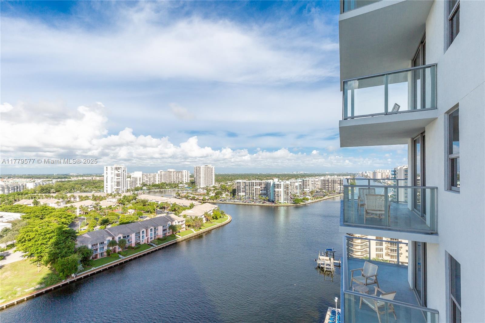 A high-rise balcony overlooks a canal, surrounding residential buildings, and a lush landscape — 4010 S Ocean Dr # R2204, Hollywood FL 33019, HOLLYWOOD, FL