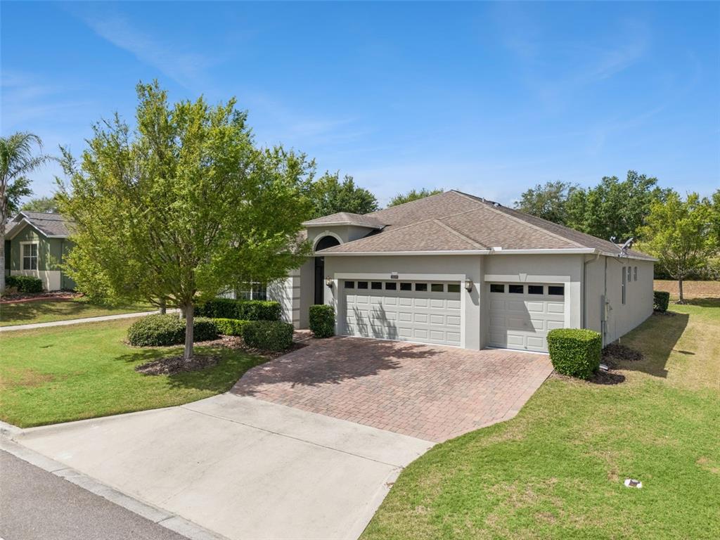 A single-story house with a three-car garage, a paved driveway, and a front yard — 3859 SANIBEL STREET, CLERMONT, FL