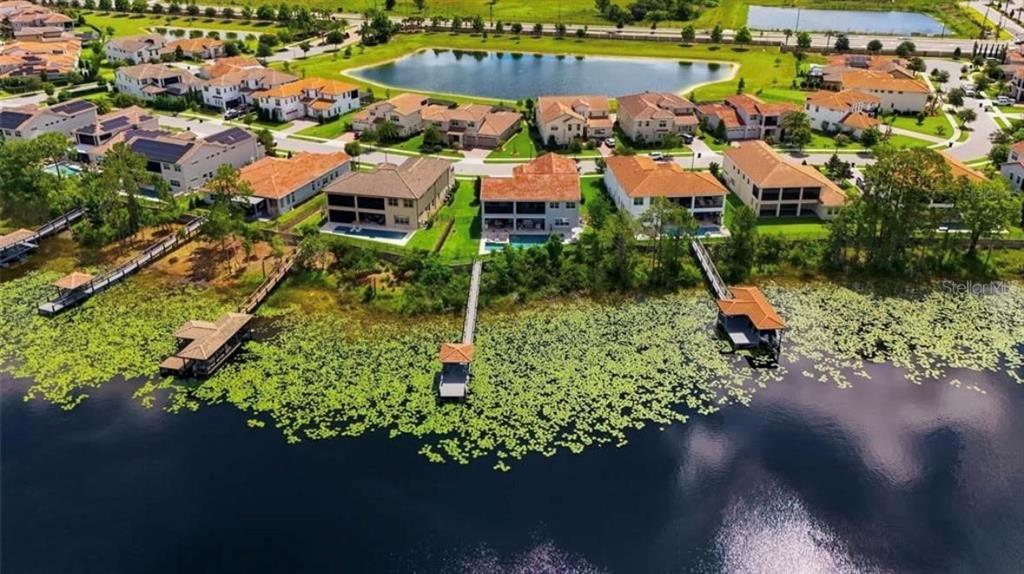 An aerial view shows waterfront houses with private docks and pools along a lake — 9110 MORGANA COURT, WINTER GARDEN, FL