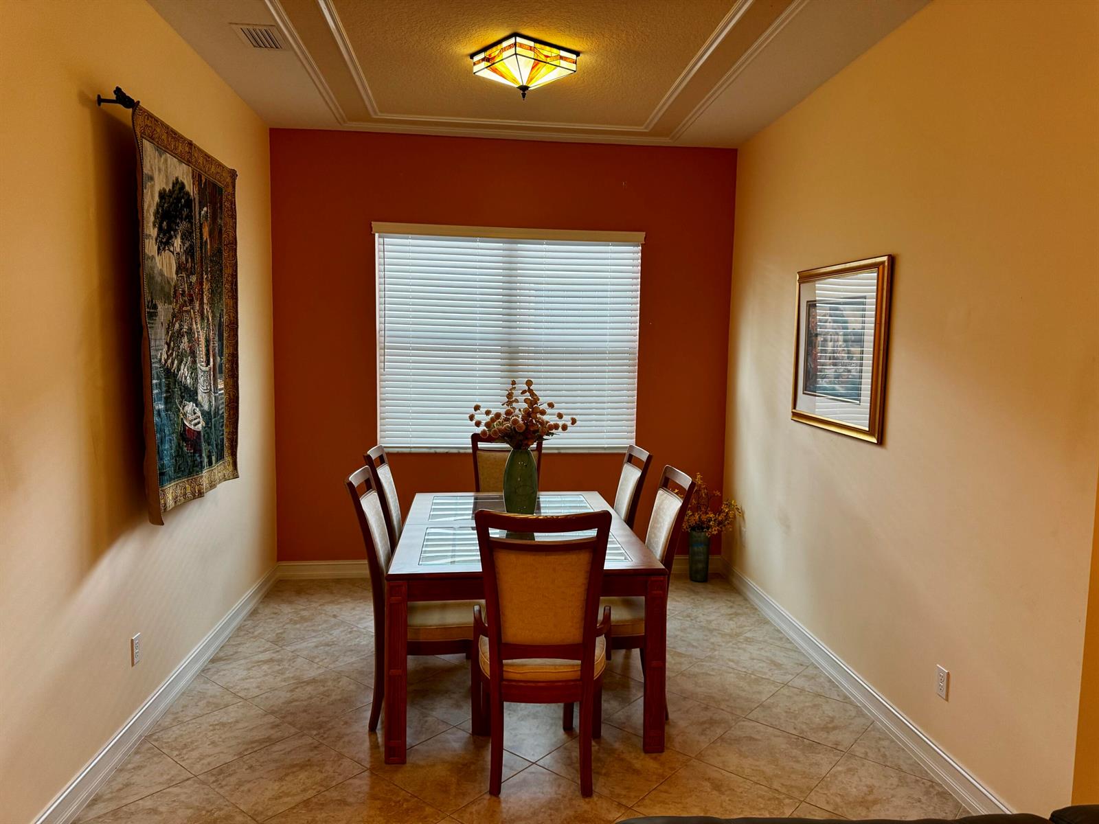 A dining room features a wooden table with six chairs, a tiled floor, and a tapestry — 9385 Ivory Isle Road, Boynton Beach FL 33473, BOYNTON BEACH, FL