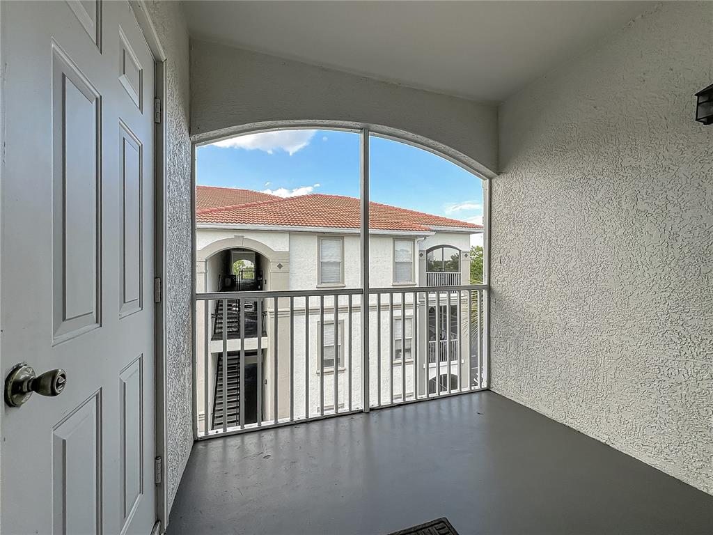 A covered balcony with a screen enclosure overlooks a neighboring apartment building — 2615 MAITLAND CROSSING WAY UNIT 9 307, ORLANDO, FL