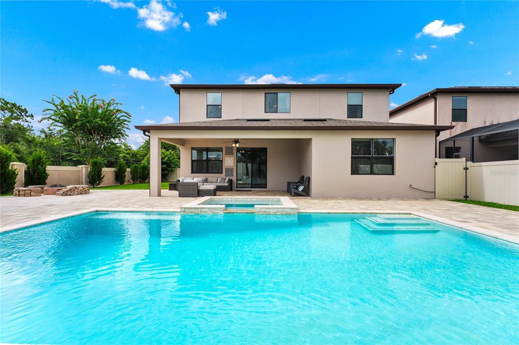 A living room features a fireplace, a chandelier, a sofa, two armchairs, and tile flooring — 10037 LEYBURN COURT, ORLANDO, FL