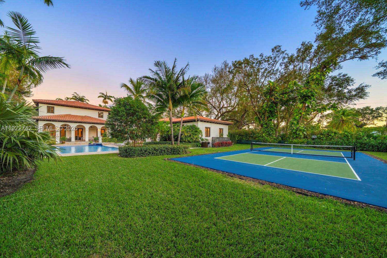 A backyard features a swimming pool, a pickleball court, and a two-story house — 8800 SW 57 Ave, Pinecrest FL 33156, PINECREST, FL