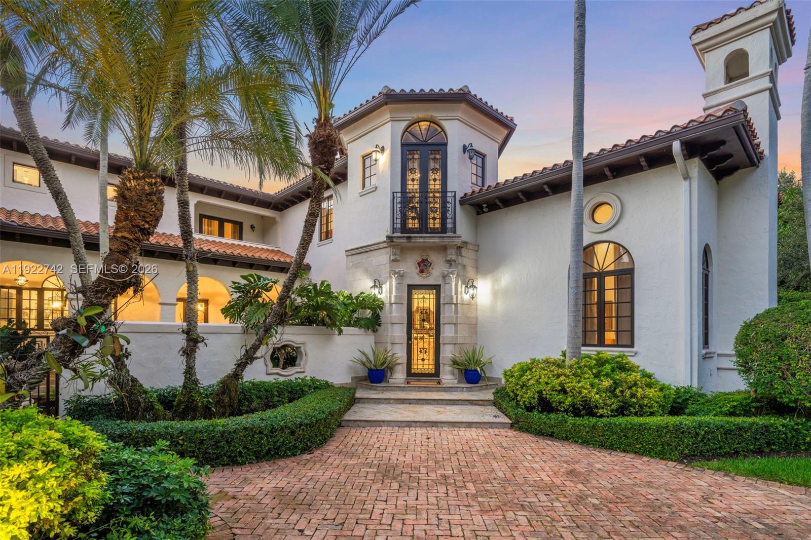 A Mediterranean-style house features a brick driveway, arched windows, and a central tower entrance — 8800 SW 57 Ave, Pinecrest FL 33156, PINECREST, FL