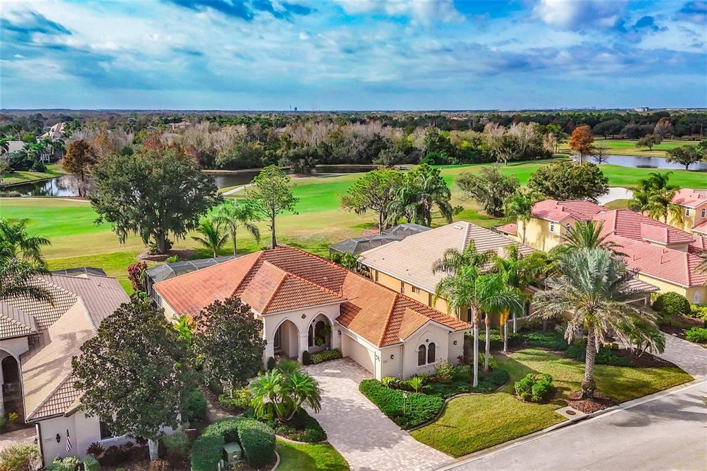 An aerial view of a suburban house with a tile roof overlooking a golf course — 7042 VILAMOURA PLACE, LAKEWOOD RANCH, FL