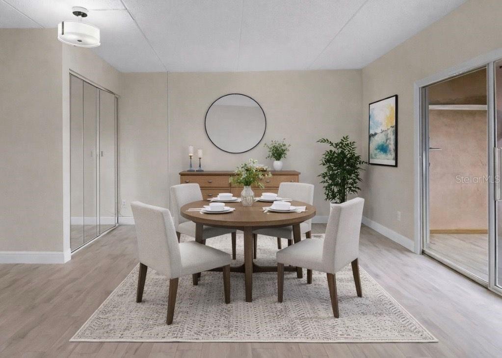 A dining room features a round wooden table, four upholstered chairs, and a circular wall mirror — 4724 CHRISTA COURT UNIT 322, TAMPA, FL