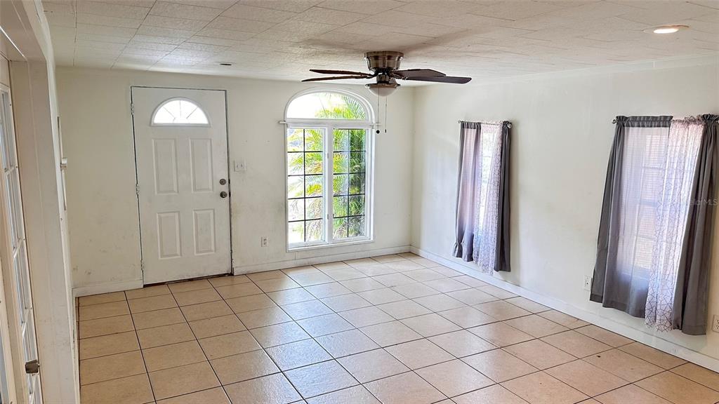 A room with tiled floors, a ceiling fan, a white door, and two windows — 5891 93RD AVENUE N, PINELLAS PARK, FL