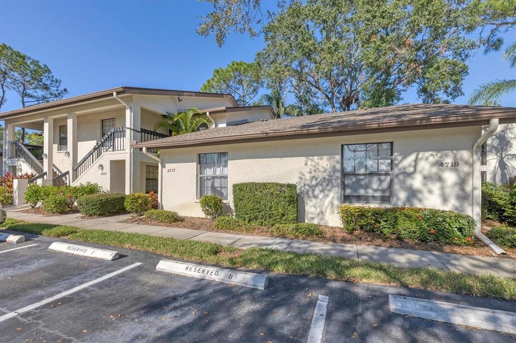A two-story apartment building with tan stucco walls and reserved parking spaces in front — 4717 WINSLOW BEACON UNIT 7, SARASOTA, FL
