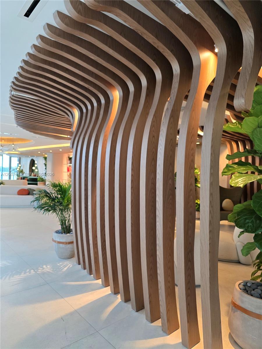 A room features a prominent, curved wooden slat partition extending from the ceiling to the floor — 700 NE 24 ST # 3104, Miami FL 33137, MIAMI, FL