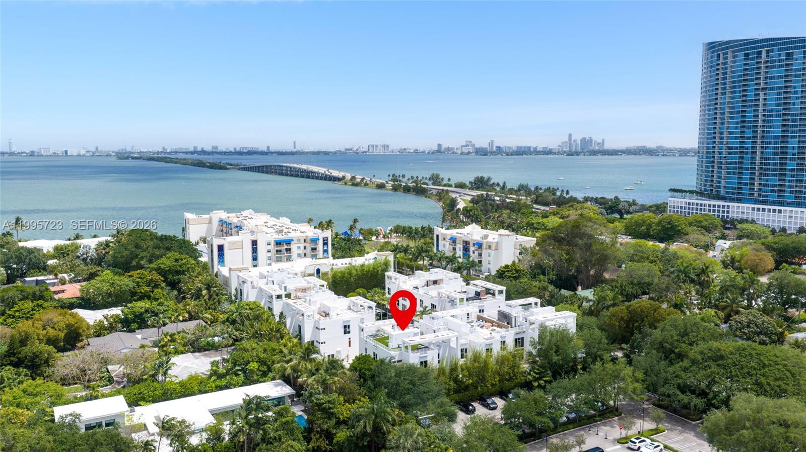 An aerial view shows a white residential complex with rooftop terraces near a bay — 455 NE 39th St # 113, Miami FL 33137, MIAMI, FL