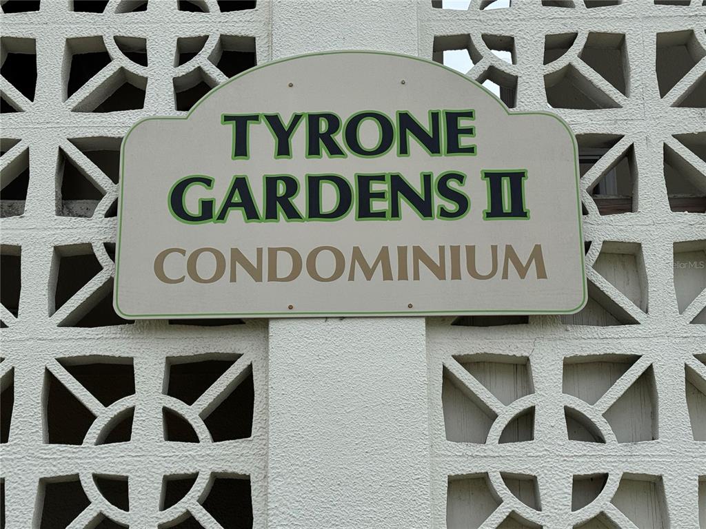 A sign for Tyrone Gardens II Condominium is mounted on a white decorative concrete block wall — 5720 13TH AVENUE N UNIT 106B, ST PETERSBURG, FL