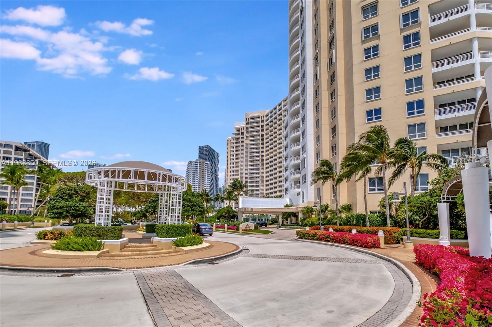 A paved driveway leads to a large apartment building with a white gazebo nearby — 848 Brickell Key Dr # 2602, Miami FL 33131, MIAMI, FL