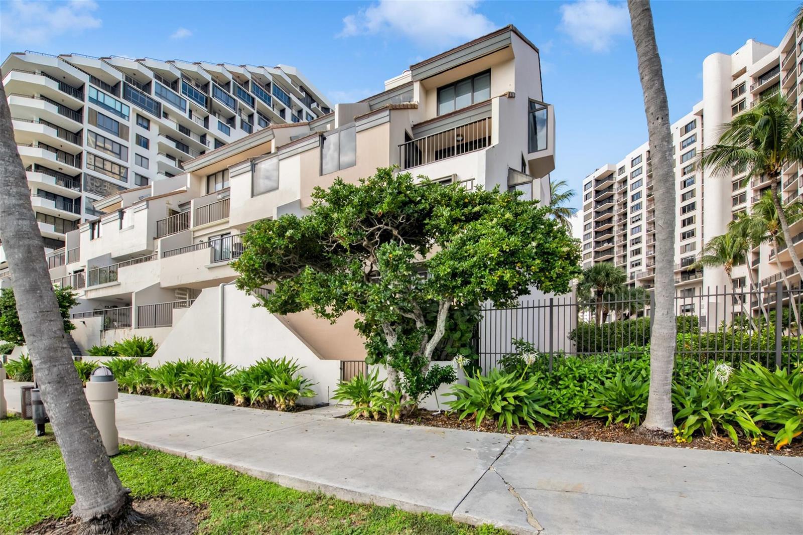 A multi-story residential building with balconies and a large tree in front of it — 520 E Brickell Key Drive, Miami FL 33131, MIAMI, FL