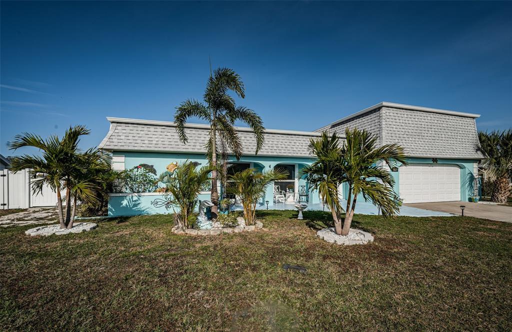 A single-story house with light blue siding, a white garage, and several palm trees — 3627 GRAYTON DRIVE, NEW PORT RICHEY, FL