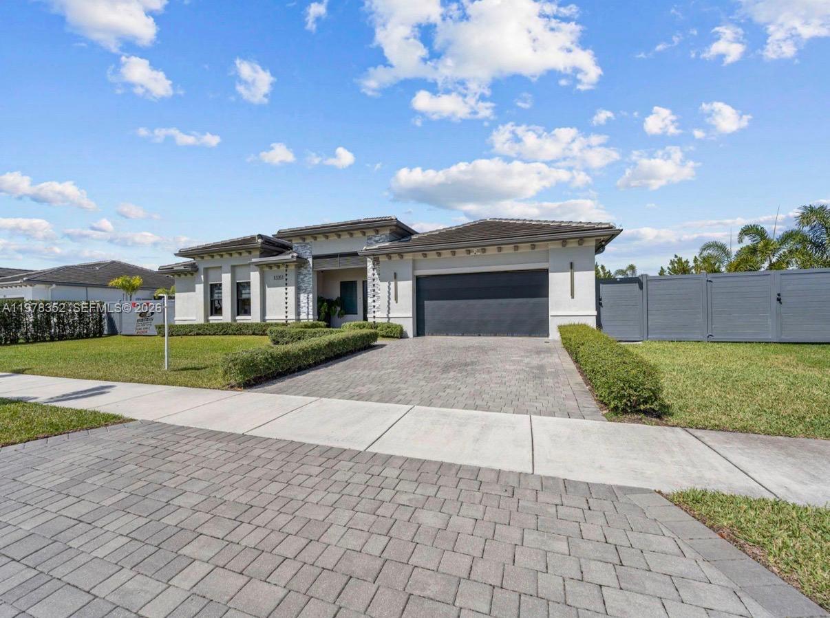 A single-story house with a paved driveway, a two-car garage, and a manicured lawn — 13351 SW 190th St, Miami FL 33177, MIAMI, FL
