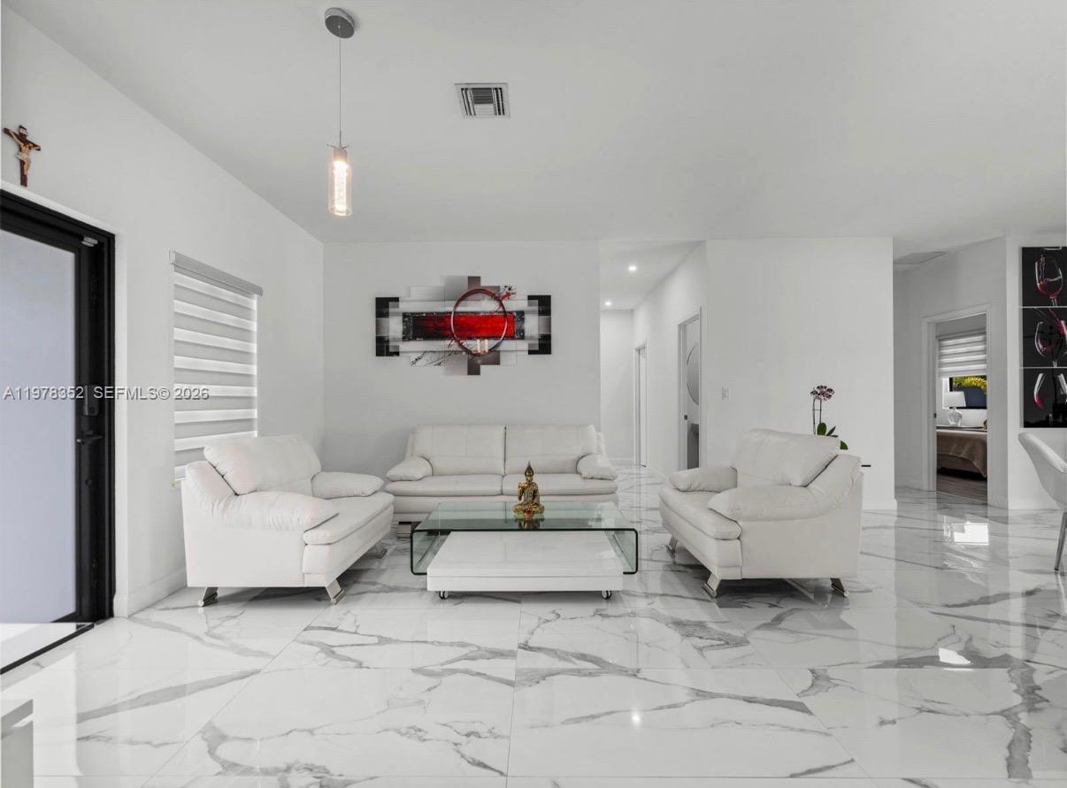 A living room features white leather furniture, a glass coffee table, and marble-patterned tile floors — 13351 SW 190th St, Miami FL 33177, MIAMI, FL