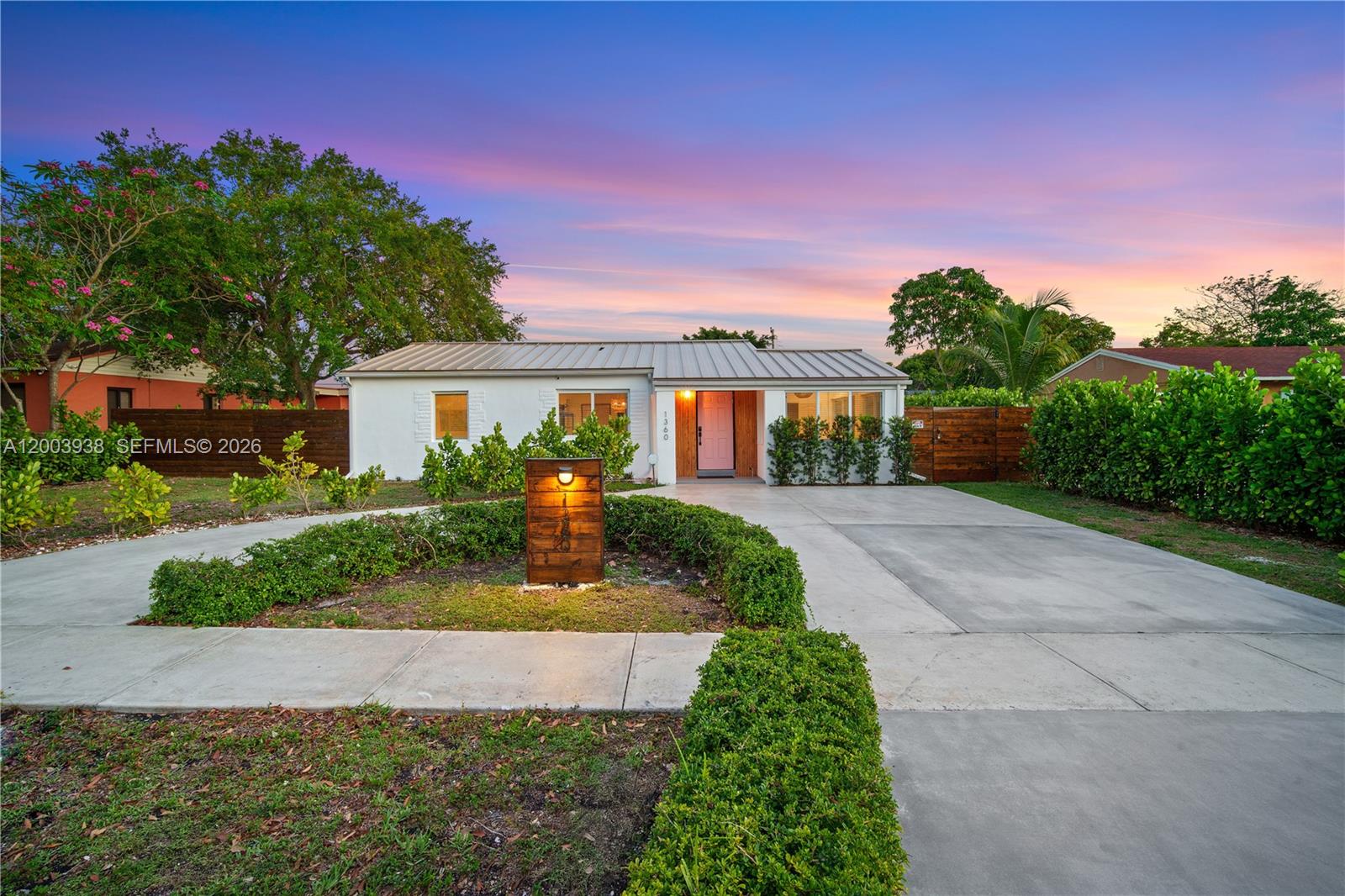 A single-story house with a metal roof, pink front door, and a concrete driveway — 1360 NE 138th St, North Miami FL 33161, NORTH MIAMI, FL