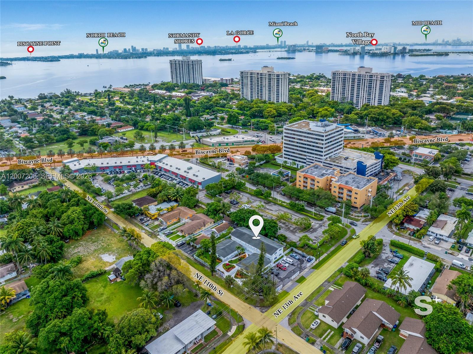 This aerial view shows a multi-unit residential building surrounded by neighborhood streets and lush greenery — 1300 NE 110th St, Miami FL 33161, MIAMI, FL