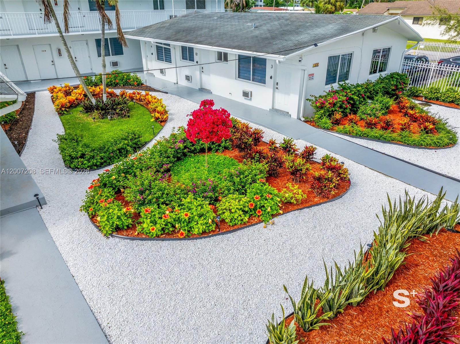 An aerial view shows a white building with landscaped garden beds and white gravel paths — 1300 NE 110th St, Miami FL 33161, MIAMI, FL
