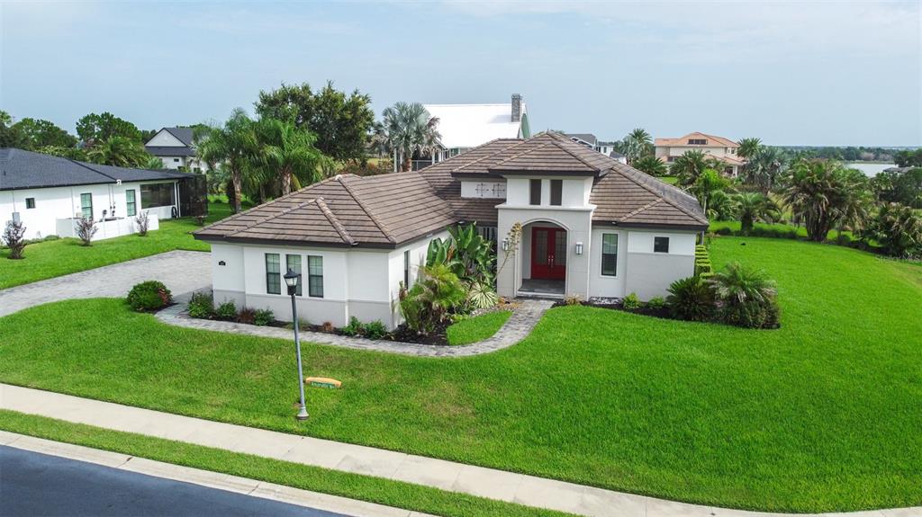 An aerial view of a single-story house with a tiled roof and red front doors — 262 AMARYLLIS WAY, LAKE ALFRED, FL