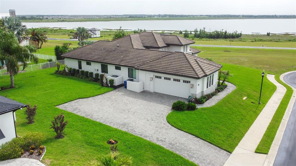 An aerial view of a single-story house with a tiled roof and a paved driveway — 262 AMARYLLIS WAY, LAKE ALFRED, FL