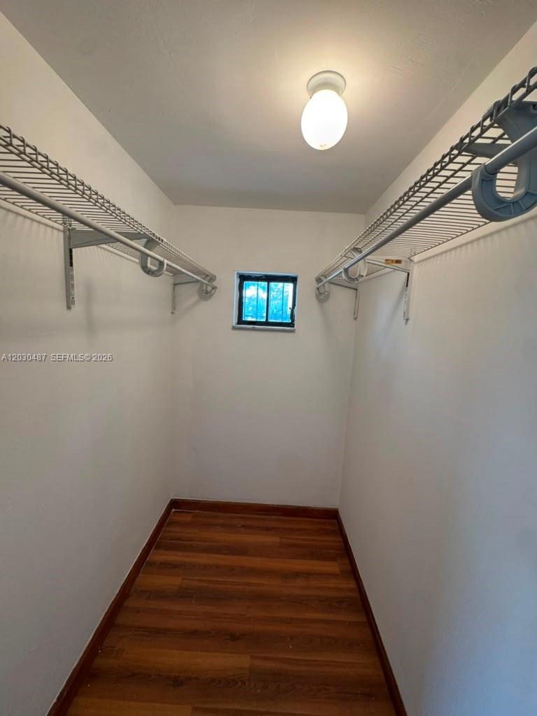 A walk-in closet features wire shelving, white walls, and wood-look flooring — 2107 Secoffee St # 3, Miami FL 33133, MIAMI, FL