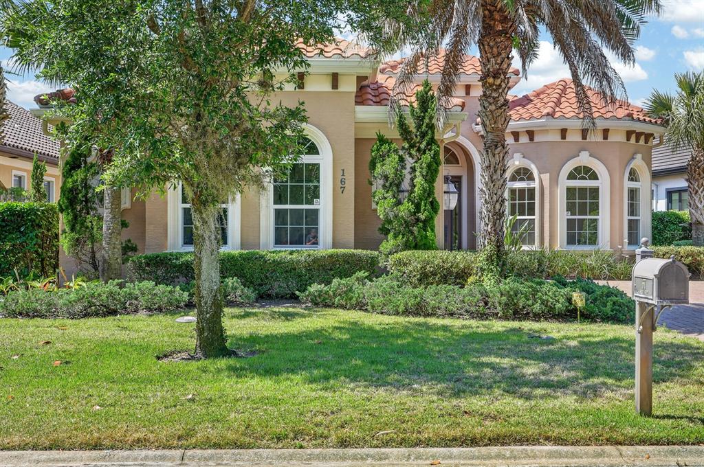 A one-story stucco house with a tile roof, arched windows, and a front lawn — 167 ASPEN WAY, PALM COAST, FL
