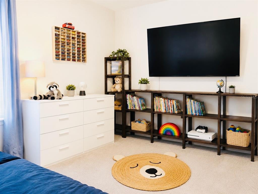 A child's bedroom features a white dresser, dark wood shelving, a television, and bear rug — 17015 OVAL RUM DRIVE, WIMAUMA, FL