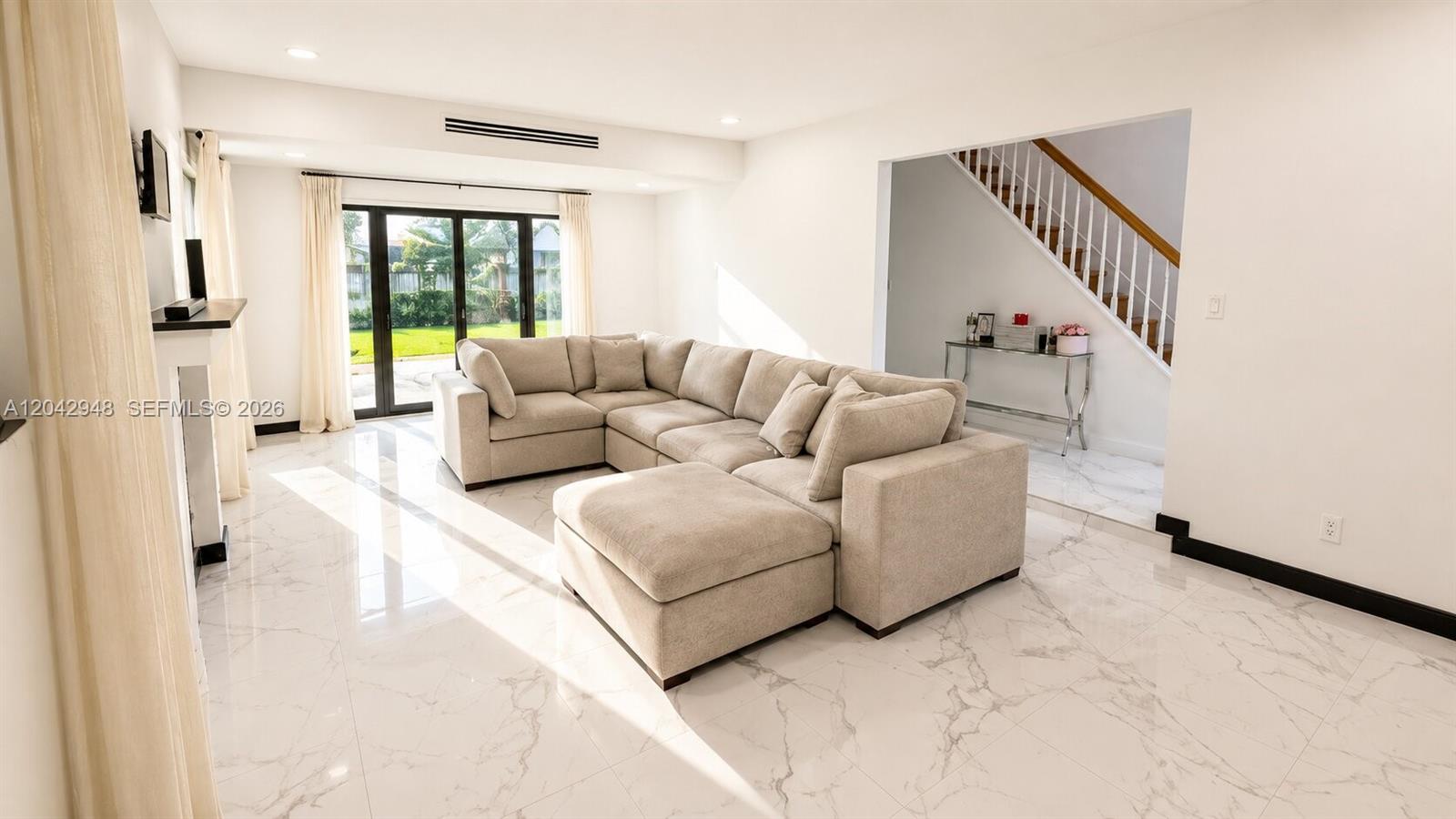 A living room features a large beige sectional sofa, white marble floors, and a staircase — 17790 SW 110th Ct, Miami FL 33157, MIAMI, FL