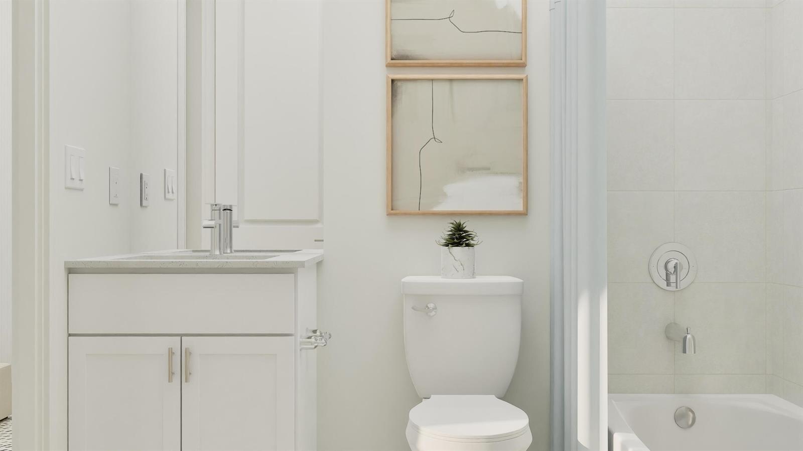 A modern bathroom features a white vanity, toilet, and a bathtub with tiled walls — 1018 Raleigh Way, Wellington FL 33414, WELLINGTON, FL