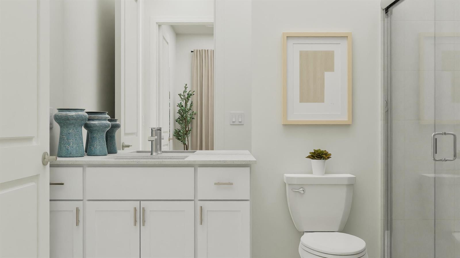 A bathroom features a white vanity, a toilet, a glass shower, and framed wall art — 1018 Raleigh Way, Wellington FL 33414, WELLINGTON, FL