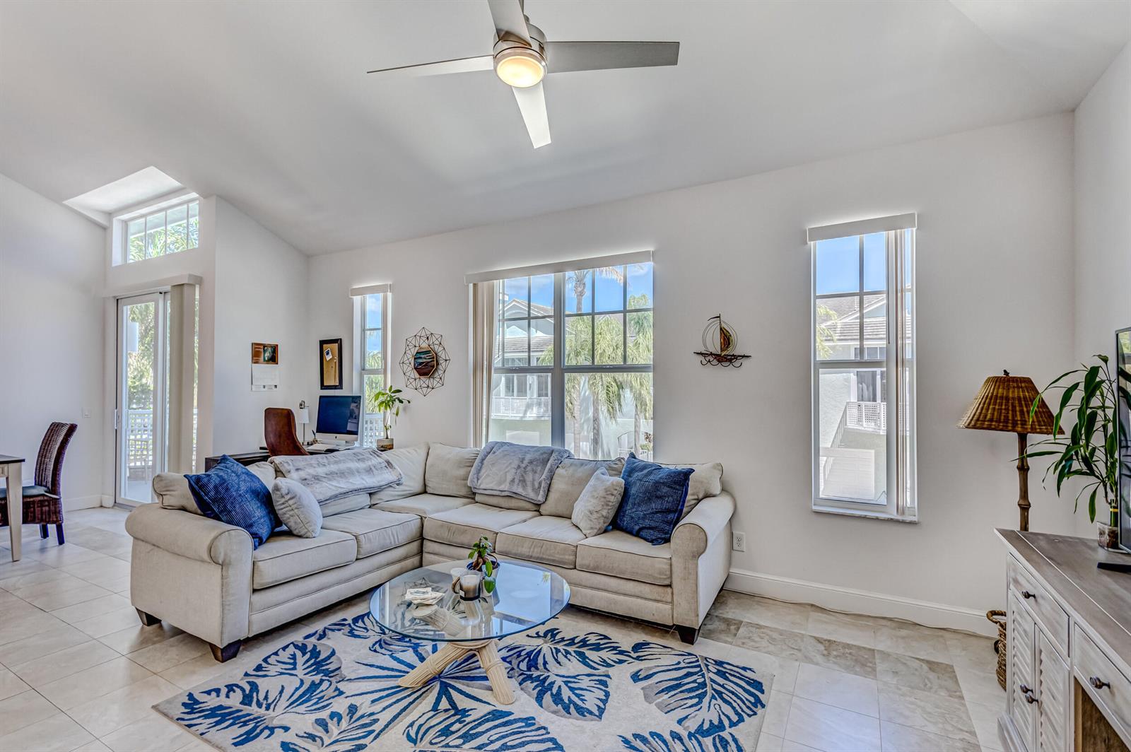 A living room features a sectional sofa, a glass coffee table, and a ceiling fan — 1701 Mizzenmast Way, Jupiter FL 33477, JUPITER, FL